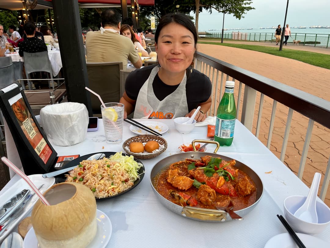 Courtney sitting in front of a big bowl of chili crab